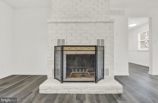 details featuring a brick fireplace and wood-type flooring