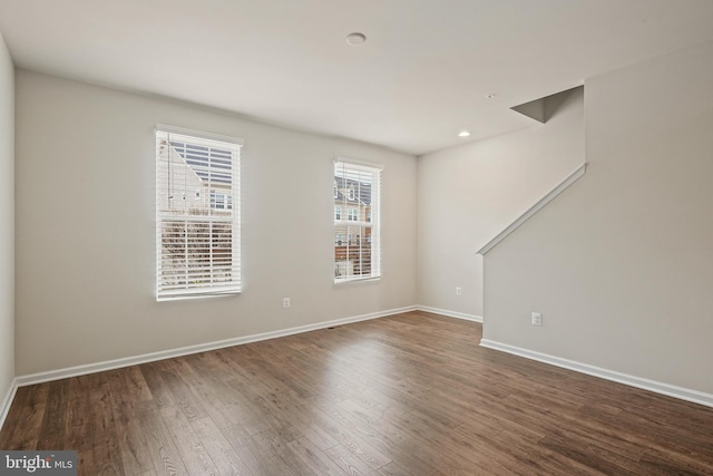 spare room featuring recessed lighting, wood finished floors, and baseboards