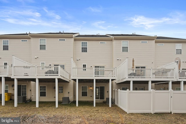 rear view of house featuring a fenced backyard, central AC unit, and a wooden deck