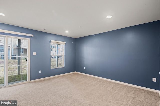 carpeted empty room featuring recessed lighting and baseboards