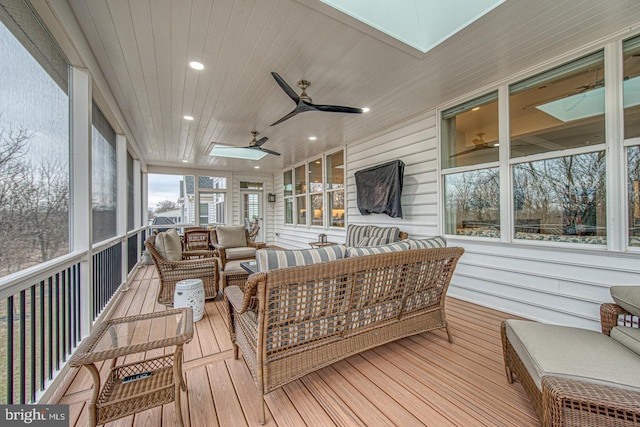 sunroom with wood ceiling, a skylight, and ceiling fan