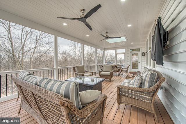 sunroom / solarium featuring ceiling fan, wood ceiling, and a skylight