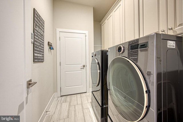 washroom featuring washer and clothes dryer and cabinets