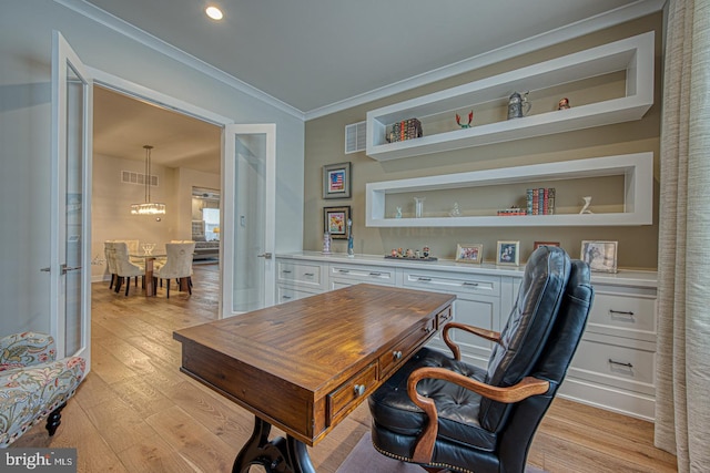 office featuring crown molding, light hardwood / wood-style floors, and built in shelves