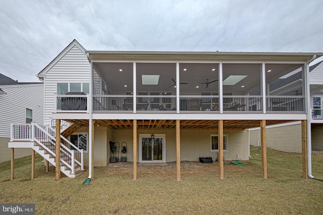 back of house featuring a wooden deck, a sunroom, a yard, and ceiling fan