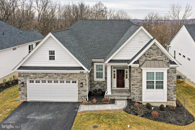 craftsman-style home featuring a garage and a front yard