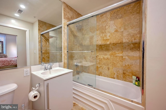 full bathroom featuring vanity, shower / bath combination with glass door, and toilet