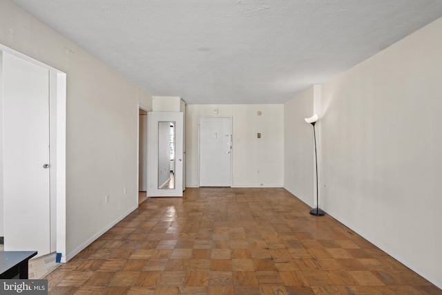 entryway featuring dark parquet flooring and a textured ceiling