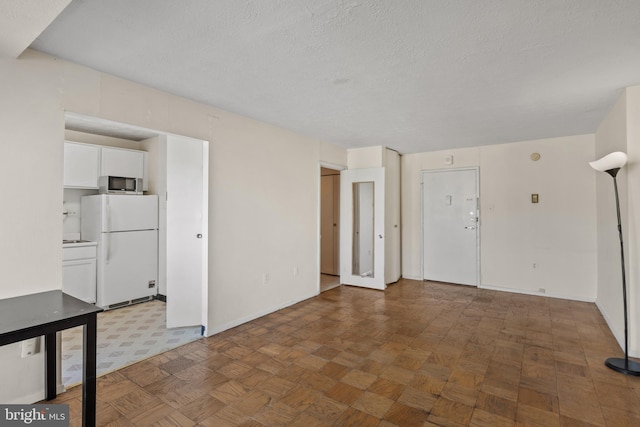 empty room with parquet flooring and a textured ceiling