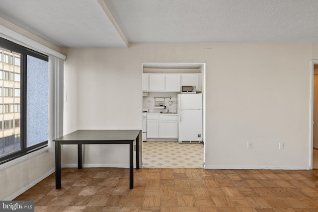 interior space featuring light parquet floors, a textured ceiling, and a healthy amount of sunlight