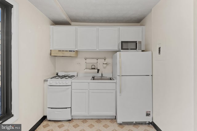 kitchen with white cabinetry, white appliances, and sink