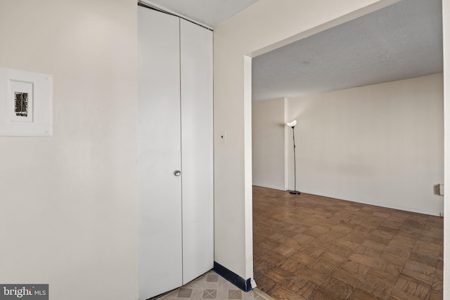 hall with parquet flooring and a textured ceiling