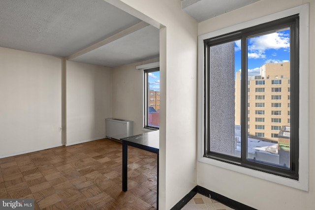 unfurnished room with parquet flooring and a textured ceiling