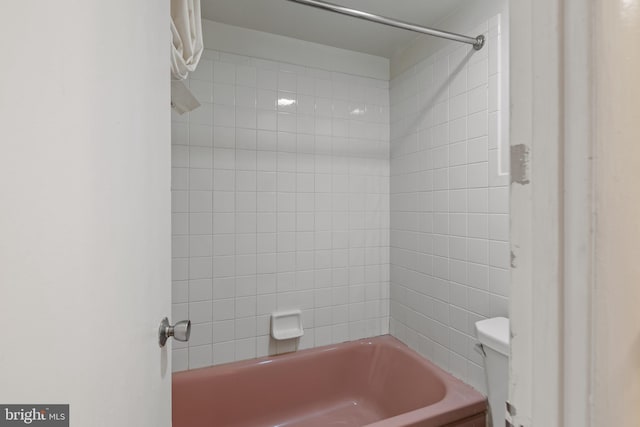 bathroom featuring tiled shower / bath and toilet