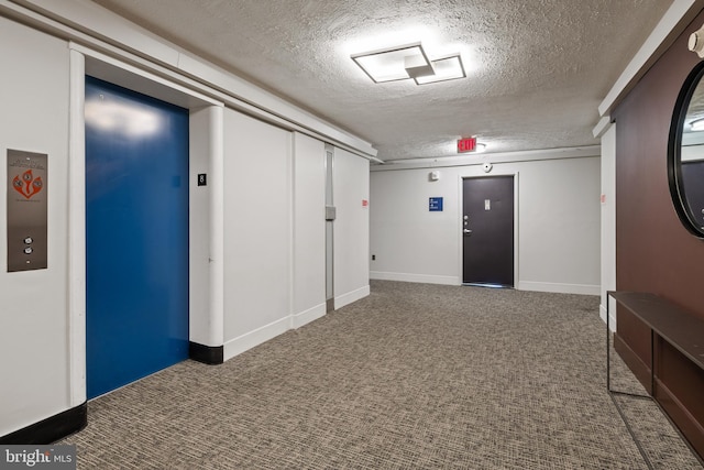 interior space with carpet floors, elevator, and a textured ceiling