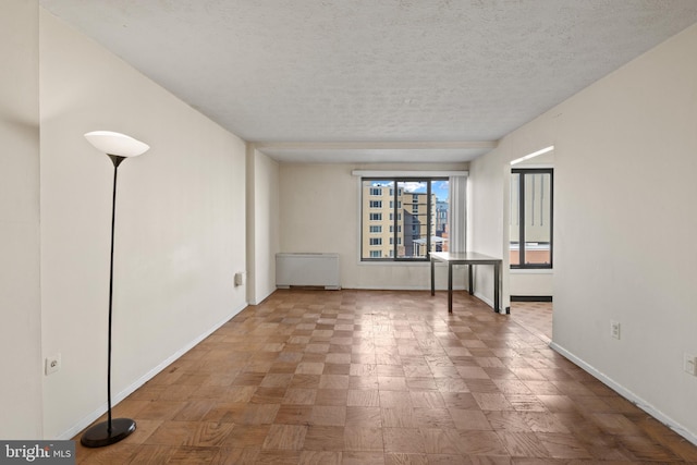 unfurnished room with a textured ceiling