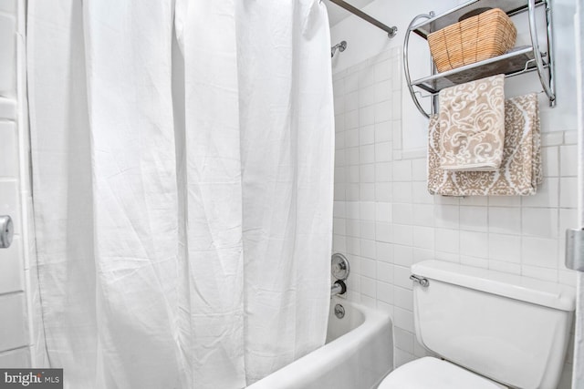 full bath featuring toilet, shower / tub combo, and tile walls