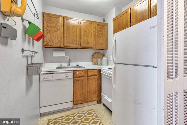 kitchen featuring white appliances, light countertops, a sink, and brown cabinetry