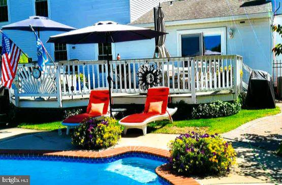 rear view of house with a pool side deck