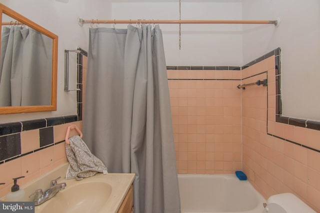 full bathroom with shower / bath combo with shower curtain, vanity, toilet, and tile walls