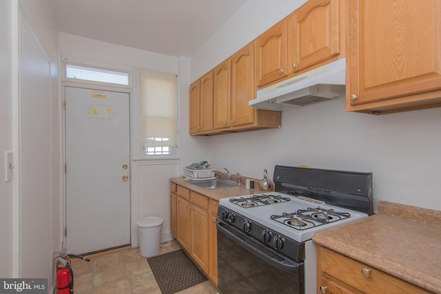 kitchen with sink, light brown cabinetry, and gas stove