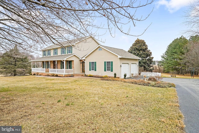 view of front of house featuring a garage, a front yard, and covered porch