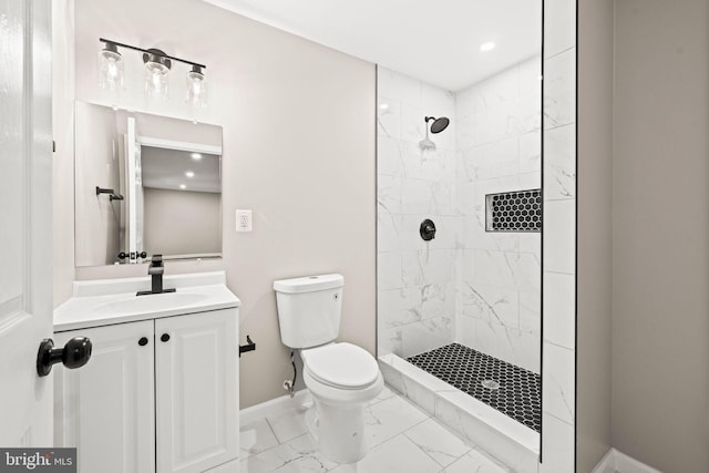 bathroom with toilet, vanity, and tiled shower