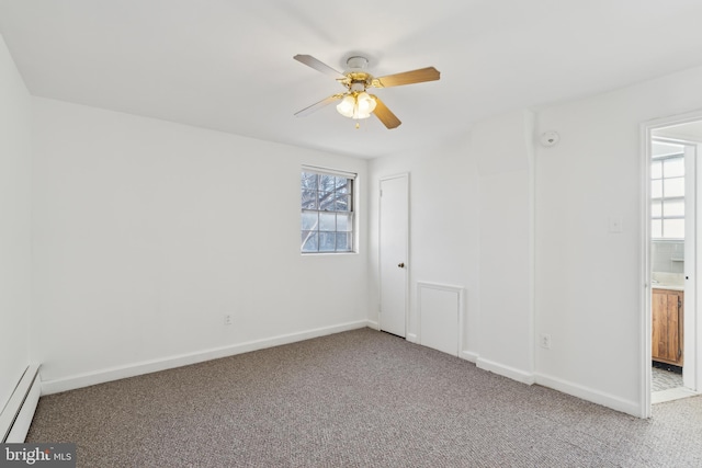 empty room with a baseboard heating unit, a wealth of natural light, ceiling fan, and carpet