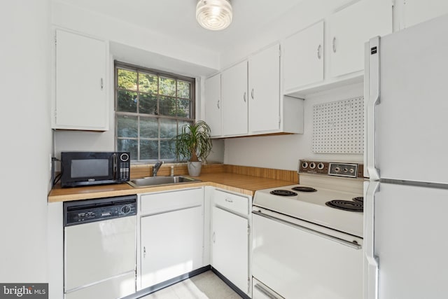 kitchen featuring light countertops, white appliances, white cabinetry, and a sink