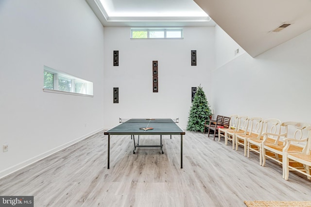 recreation room with baseboards, light wood-style floors, and a healthy amount of sunlight