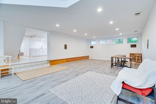 living area with light wood-style floors, baseboards, visible vents, and recessed lighting