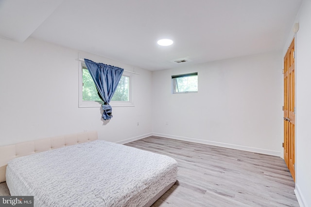 bedroom featuring wood finished floors, visible vents, and baseboards