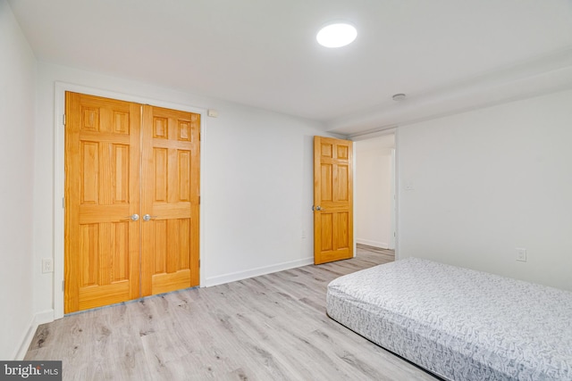 bedroom with light wood-type flooring and baseboards