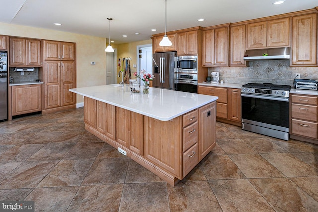 kitchen featuring tasteful backsplash, a kitchen island with sink, stainless steel appliances, light countertops, and wall chimney range hood