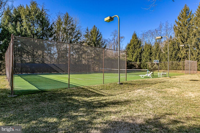 view of sport court featuring a yard, fence, and community basketball court