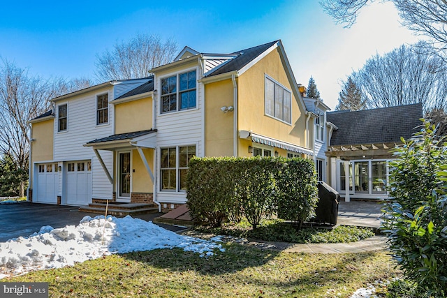 view of front of home with aphalt driveway, a garage, and stucco siding