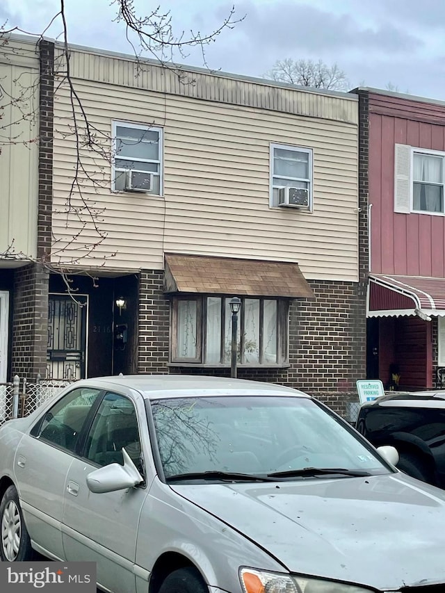 townhome / multi-family property featuring cooling unit and brick siding