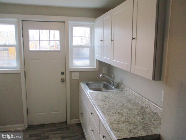 laundry area featuring dark hardwood / wood-style flooring and sink