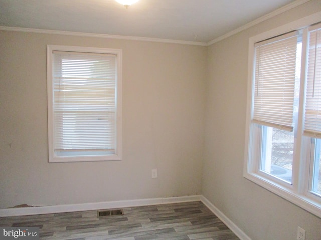 empty room with crown molding and wood-type flooring