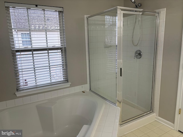 full bath featuring a garden tub, a shower stall, and tile patterned floors