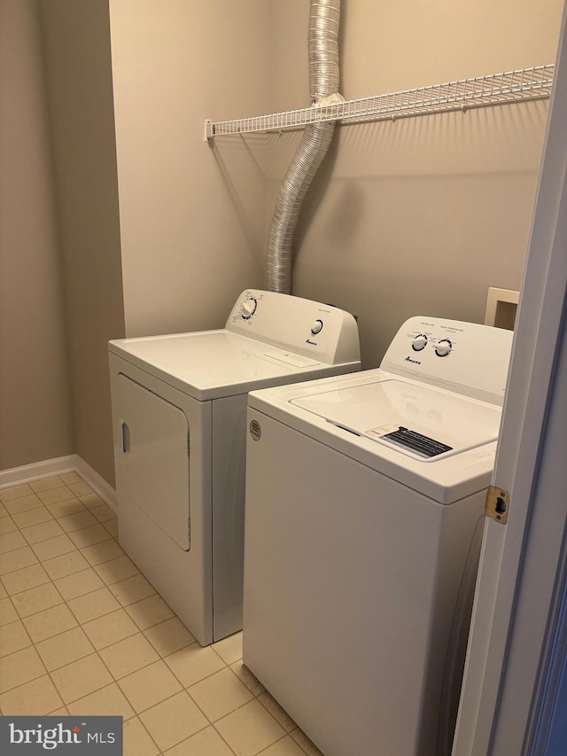 laundry area with washing machine and dryer, laundry area, and light tile patterned floors