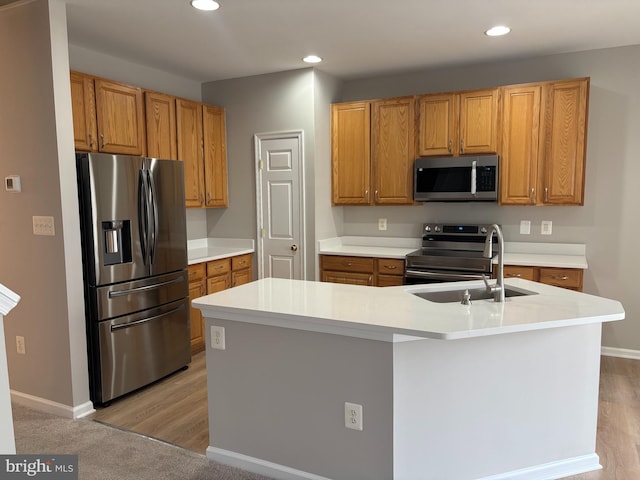 kitchen featuring an island with sink, stainless steel appliances, light countertops, and recessed lighting