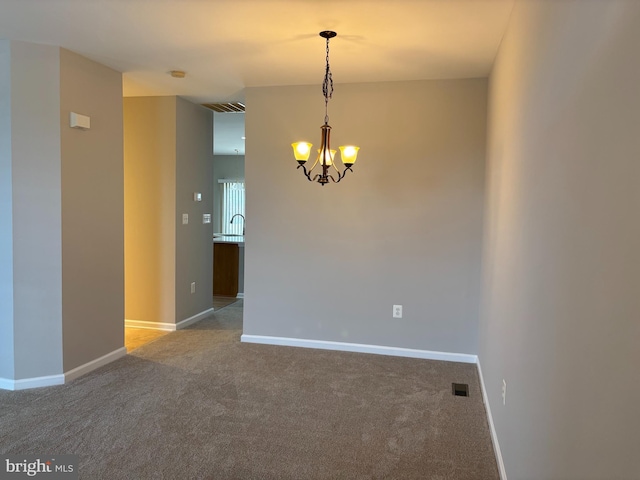 unfurnished room featuring a chandelier, light colored carpet, visible vents, and baseboards