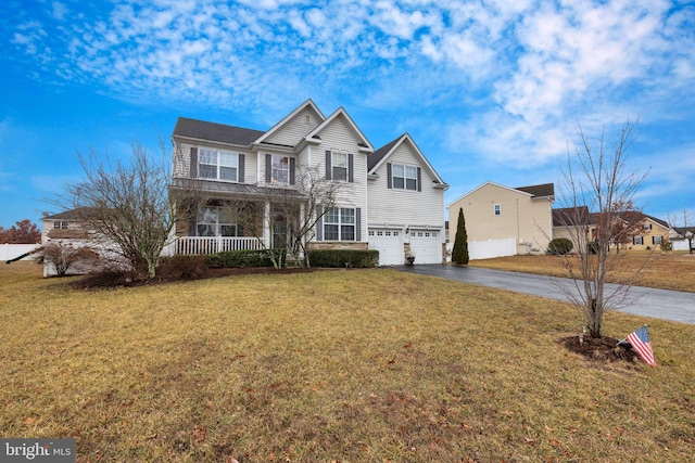 view of front of property featuring a garage, a front yard, and a porch