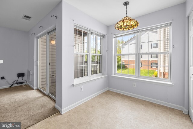 unfurnished dining area with baseboards, visible vents, and a wealth of natural light