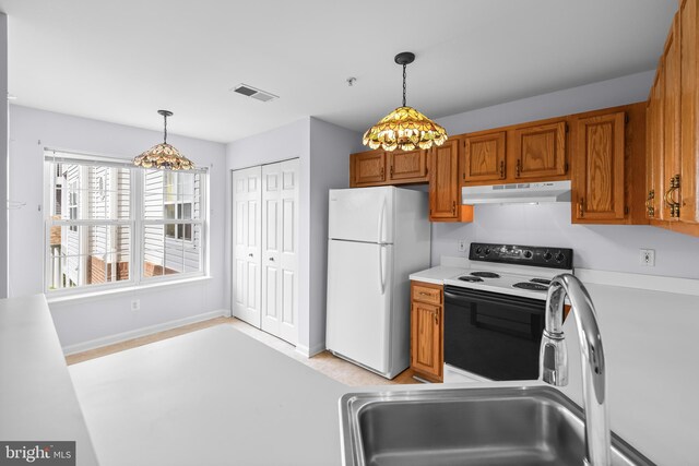 kitchen with electric range oven, under cabinet range hood, a chandelier, and freestanding refrigerator