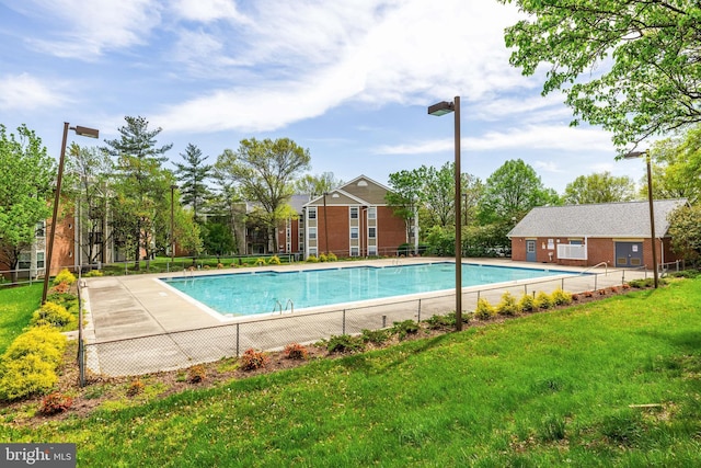 pool with fence and a yard