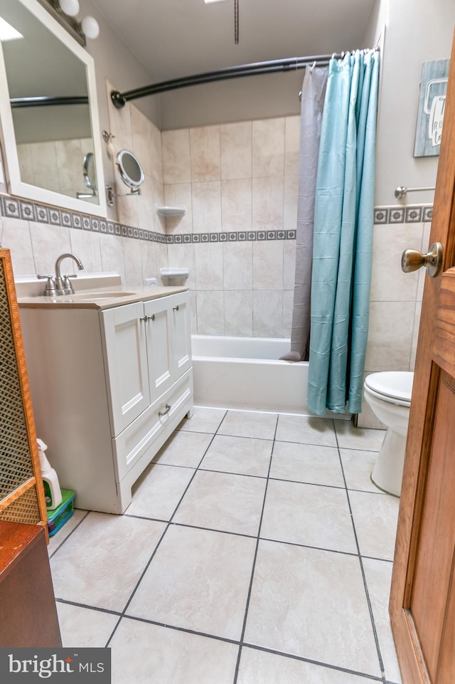 full bathroom featuring tile patterned floors, toilet, tile walls, vanity, and shower / bath combination with curtain