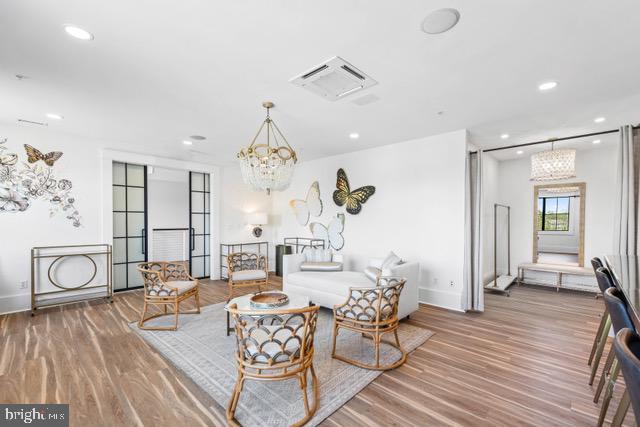 living room featuring wood-type flooring and a chandelier