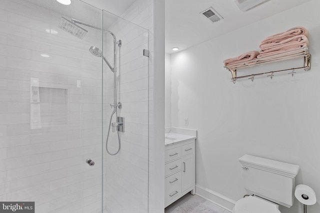 full bathroom featuring toilet, tiled shower, vanity, and visible vents